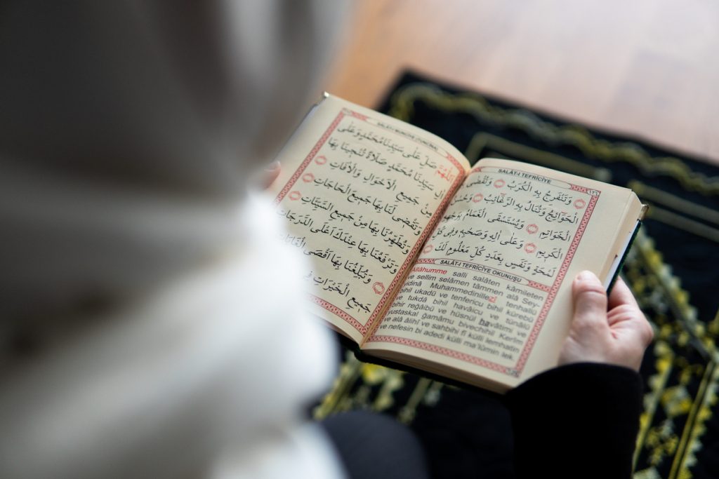 Muslim woman reading from the quran stock photo